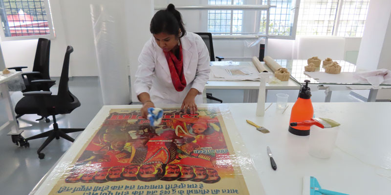Burnishing the lined poster to remove any air bubbles that may form
