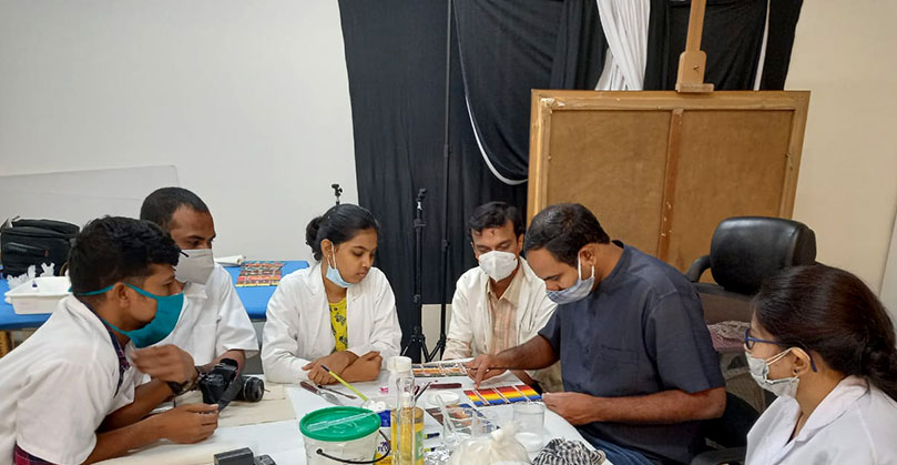 Visiting faculty Kyam Khan demonstrating filling and texturing processes on dummy samples of oil paintings.