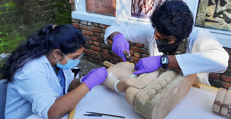 Trainee conservators undertaking surface cleaning and reassembly of a broken sculpture