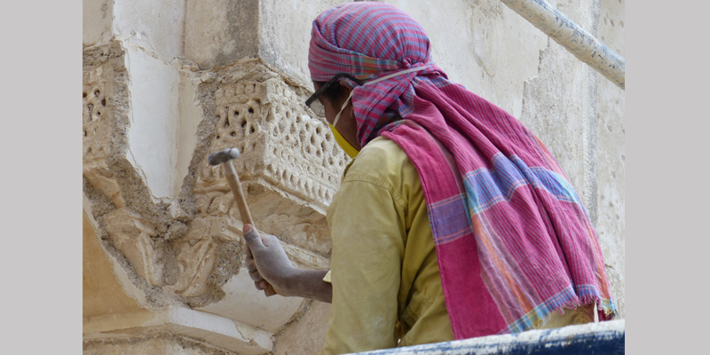 Removal of 20th century plaster revealing original stucco details from 1500s