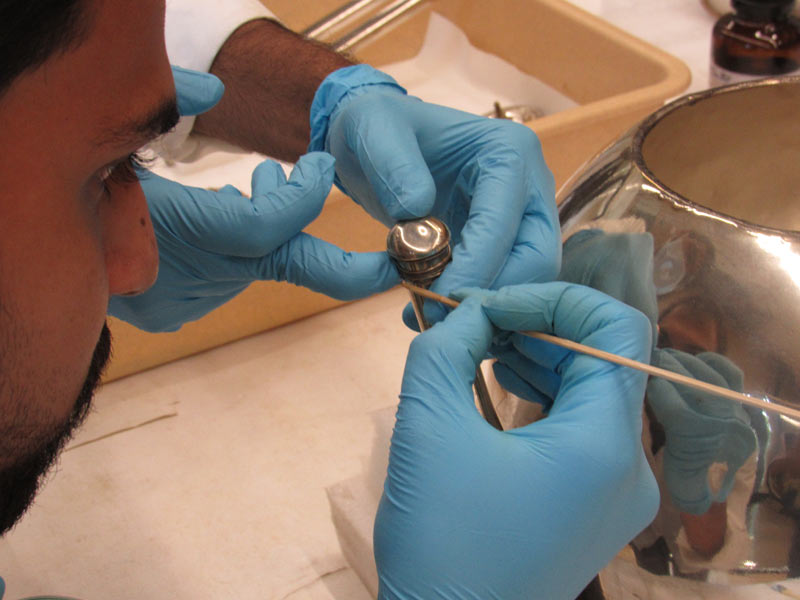 Participant fixing a silver wire on the silver trophy object