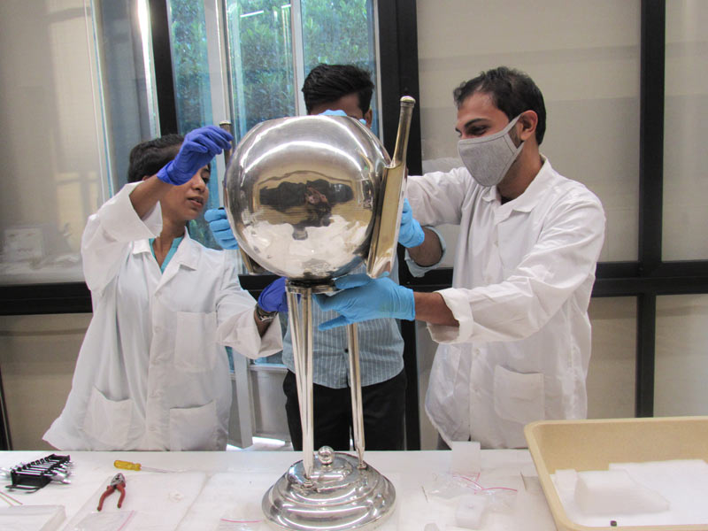Participants reassembling a silver trophy object post conservation treatment