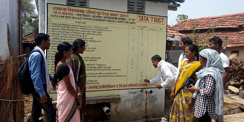 Community members using wall-paintings to track progress in achieving priority line items in their Village Development Plan