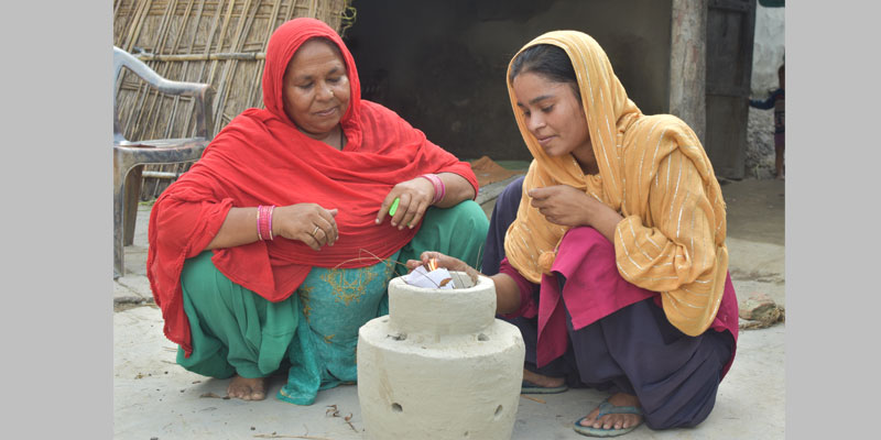 Najma and her daughter use a matka incinerator for the hygienic disposal of used menstrual absorbents