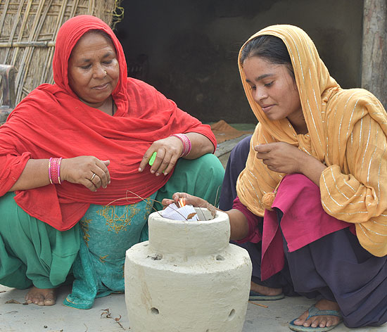 Najma and her daughter use a matka incinerator for the hygienic disposal of used menstrual absorbents