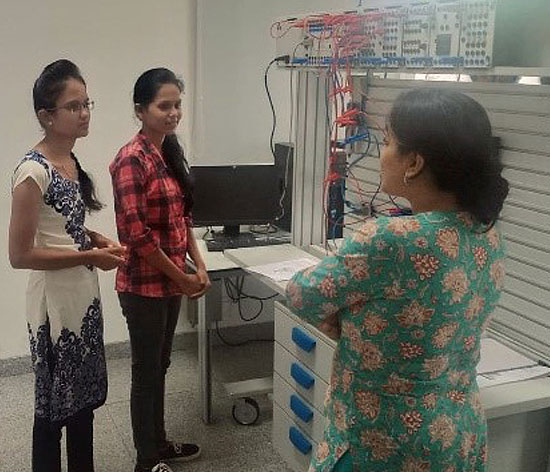 Anjali and her classmate in conversation with one of the instructors