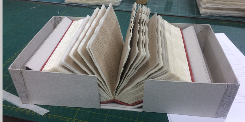 A conserved book placed in an acid free jacket, ready for storage