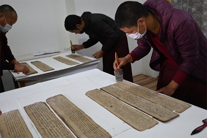 Participants undertaking dry cleaning of manuscript folios