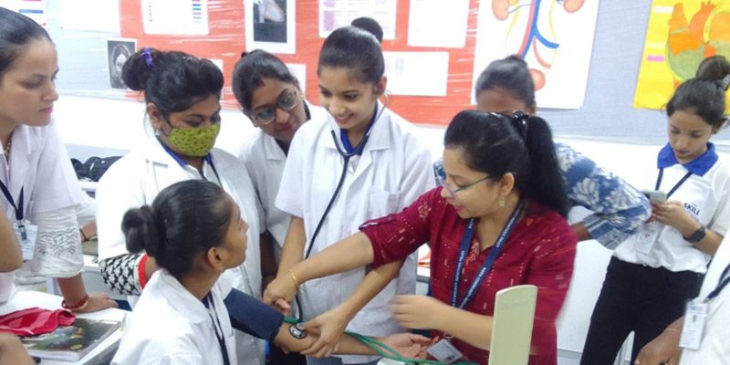 A Tata STRIVE instructor shows GDA students how to accurately measure blood pressure