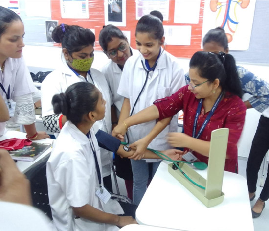 A Tata STRIVE instructor shows GDA students how to accurately measure blood pressure