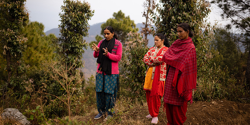 Villagers explaining trench for rainwater collection