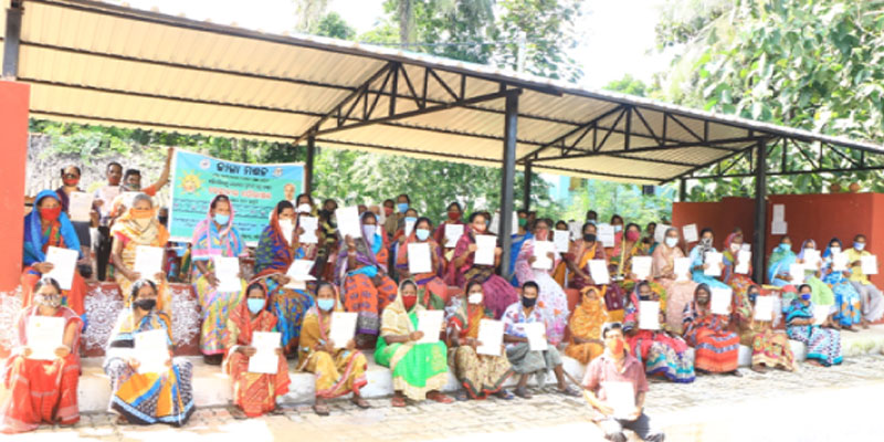 Beneficiaries of Kathagada Parbatia Sahi Slum proudly holding their Land Entitlement certificates. Land Entitlement certificates are an interim measure to give statutory recognition and an assurance of grant of land rights to slum dwellers.