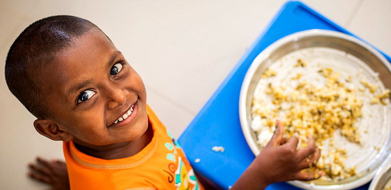 Children enjoying their mid-day meal of fortified rice
