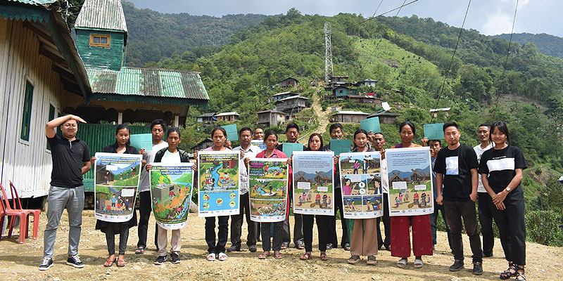 Residents of New Chingmei village with Social and Behavioural Change Communication posters