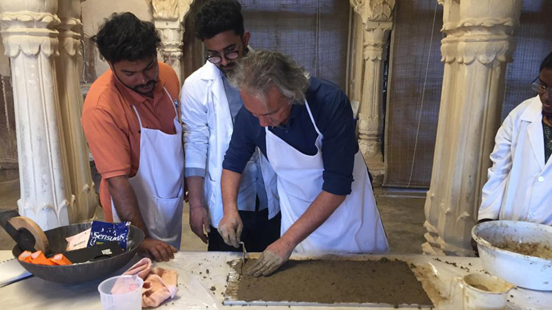 Course leader Anupam Sah demonstrating application of mud plaster replicating the plaster composition of Ajanta cave paintings