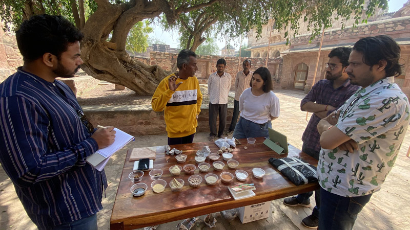 Master craftsman Faizu Khan demonstrating the preparation of araish plaster at Nagaur Fort during a site visit
