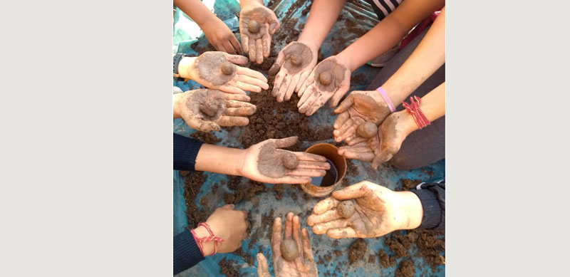 Children from the MIS School make seedballs