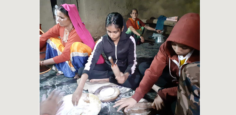 Children learning to cook with local women