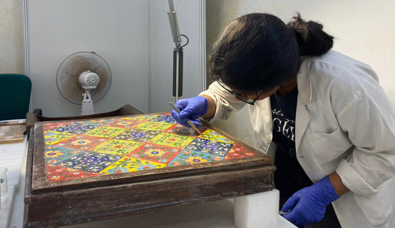 Participant undertaking removal of accretions from the surface of a wooden object