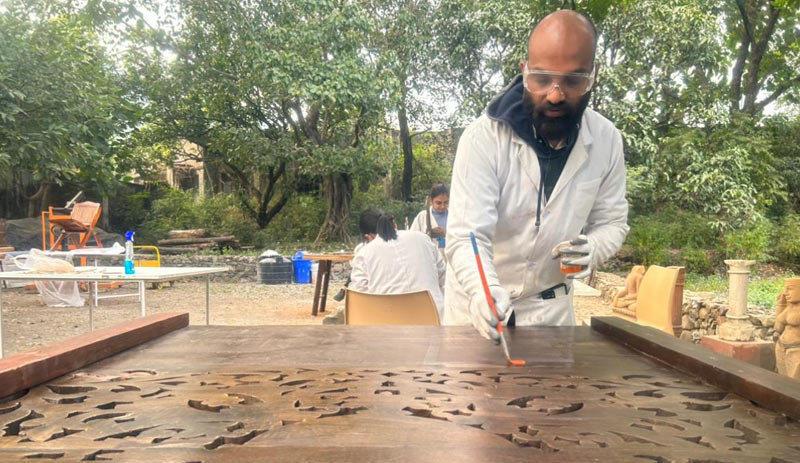 Participant applying appropriate surface coating on a treated wooden panel