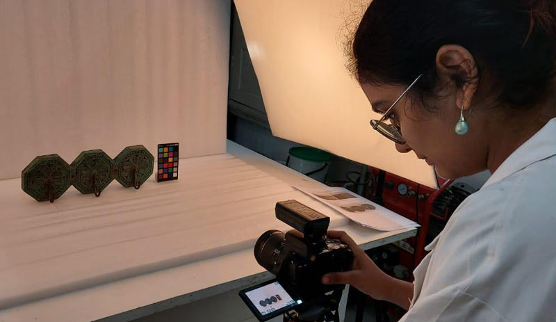 Participant undertaking the photographic documentation of an octagonal wooden hanger