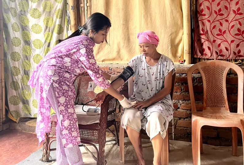 Health worker checking the blood pressure of a cancer survivor