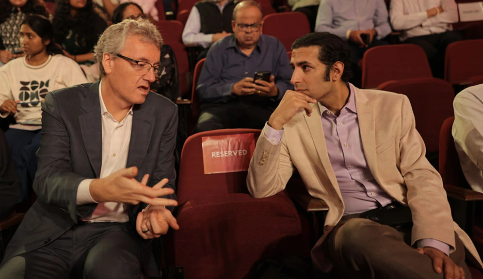 Nobel Laureate David MacMillan and biotech entrepreneur Kush Parmar engage in conversation while seated among the audience at the Nobel Prize Dialogue India 2025.
