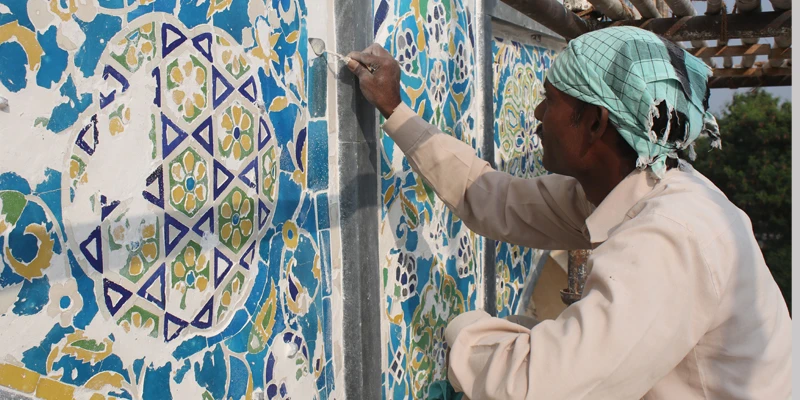 Craftsmen conserving the glazed mosaic tiles at the Tomb of Ibrahim Quli Qutb